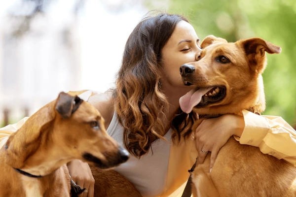 A woman cuddling her dogs